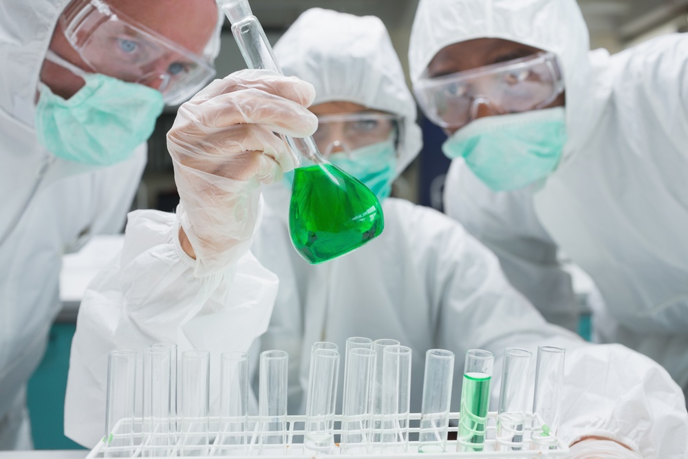 three scientists in a laboratory with green petri dish